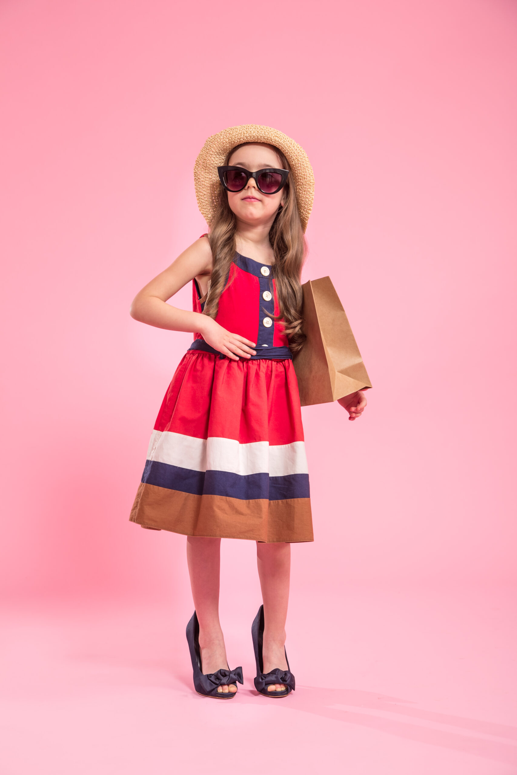 little fashionista on a colored background in mom's shoes